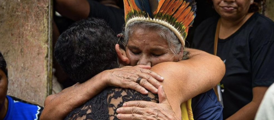 María Muñiz Tupinambá, sorella della leader indigena assassinata María de Fátima Muñiz Pataxó "Nega", viene abbracciata da un partecipante alle esequie.