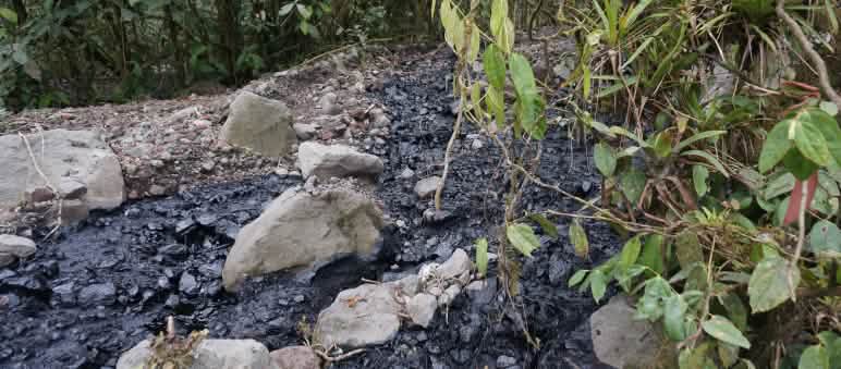 Inquinamento da petrolio nell’Amazzonia equatoriana Petrolio grezzo rovesciato su un'area coperta di ghiaia e pietre