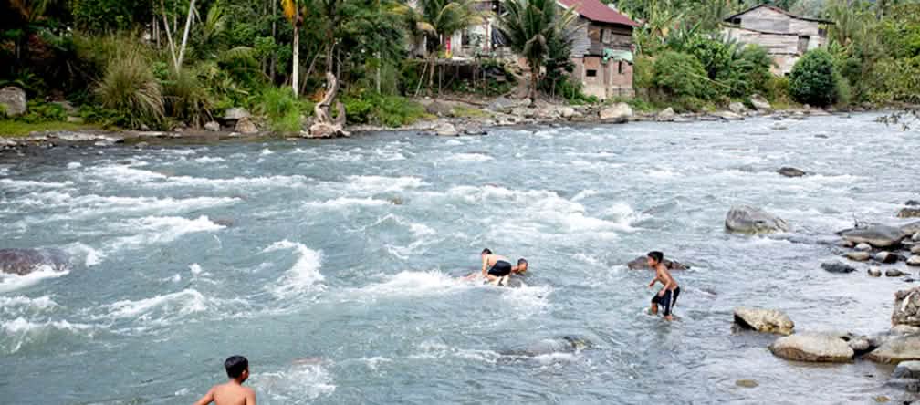 Bambini che si godono un bagno rinfrescante nel fiume Meureubo Bambini nel fiume