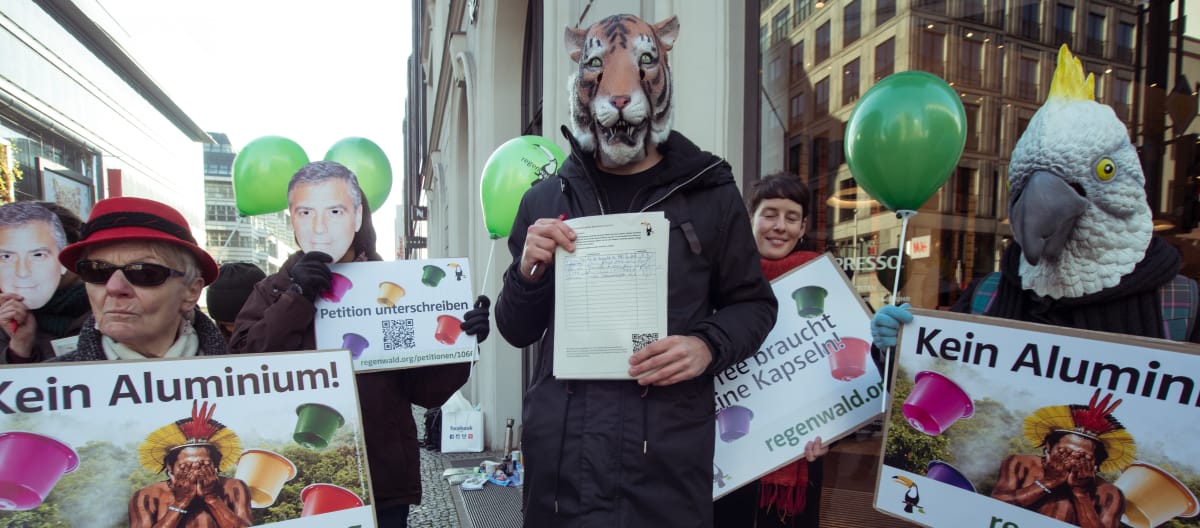 I manifestanti con maschere di animali tengono in mano dei cartelli.