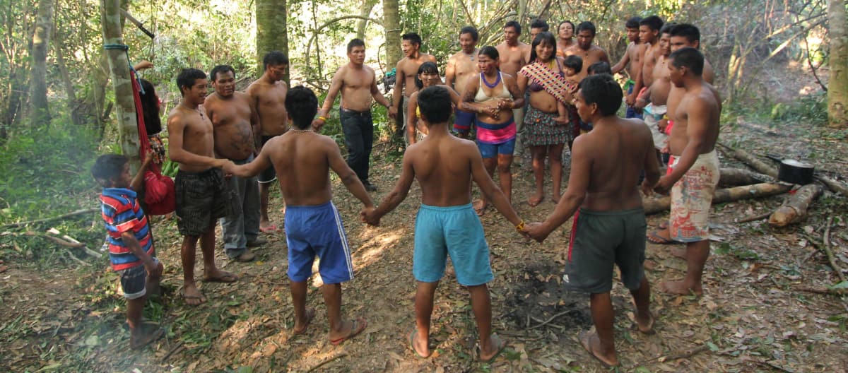 Gli indigeni Ka'apor - bambini, donne e uomini - uniscono le loro mani e formano un cerchio nella foresta tropicale.