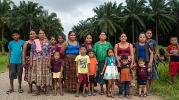 Gruppo di donne e bambini della comunità guatemalteca Chapín Abajo, messa all'angolo dalle piantagioni di palma africana.