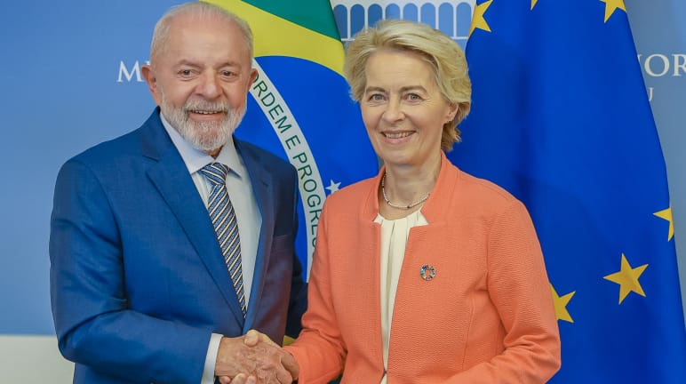 La Presidente della Commissione europea Ursula von der Leyen stringe la mano al Presidente brasiliano Lula da Silva davanti alle bandiere del Brasile e dell'UE.