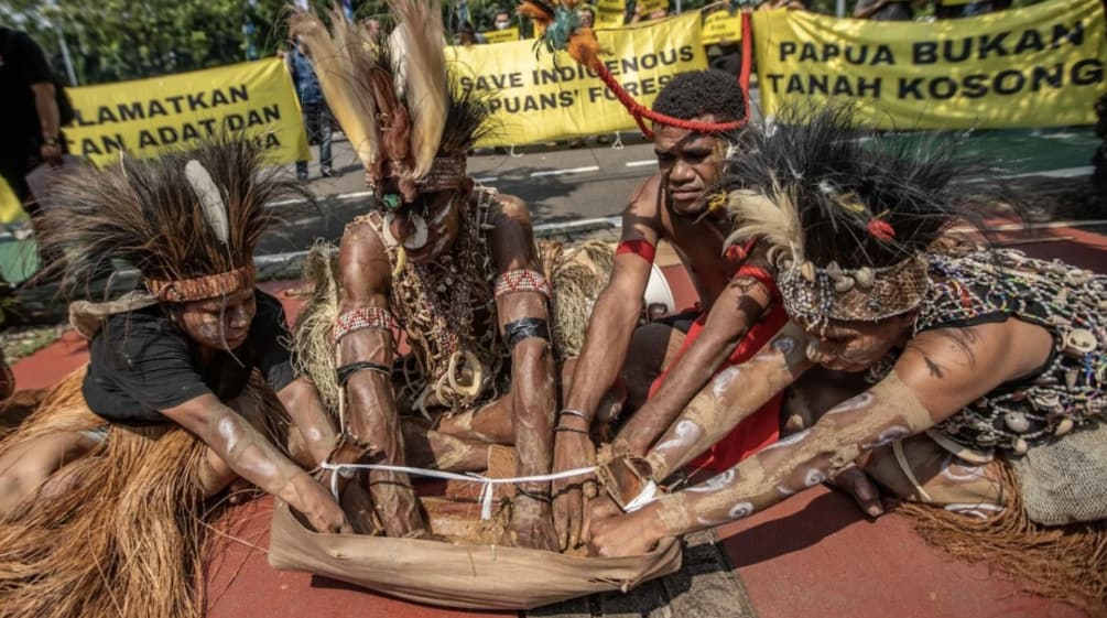 Quattro papuani con gioielli di piume eseguono un rituale. "Papua non è una terra vuota