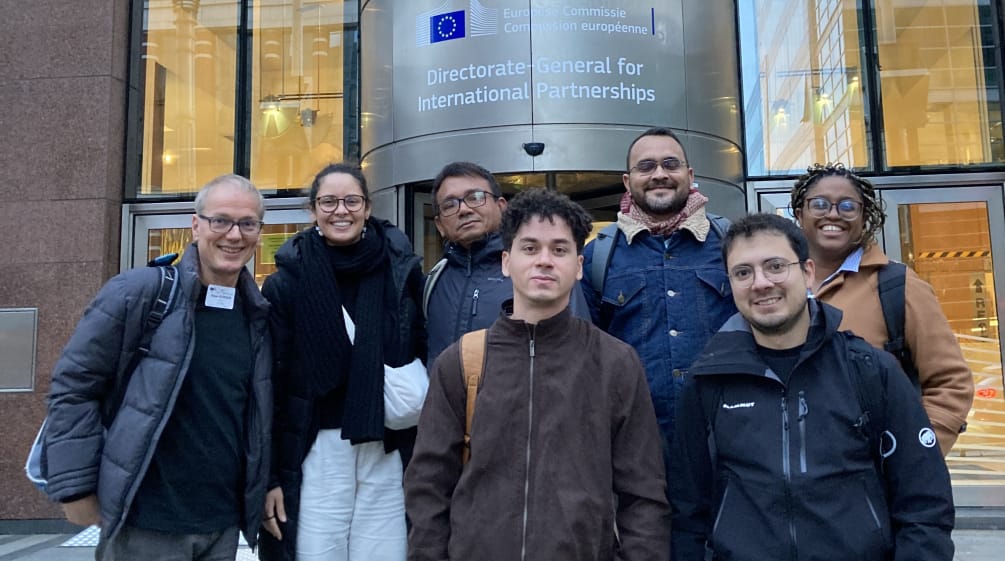 Foto di gruppo di 7 persone davanti all'ingresso di un edificio della Commissione europea a Bruxelles.