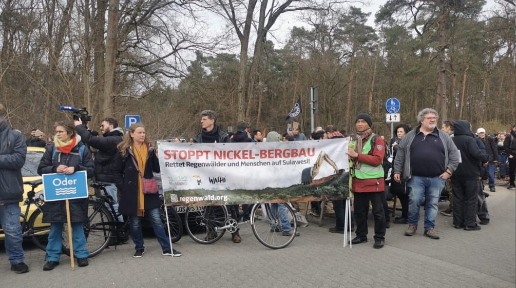 Striscione "Stop Nickel Mining", tenuto da Stefanie Hess e Boboy Simanjuntak insieme ad altri partecipanti alla protesta contro Tesla.